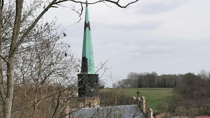 Kirchturm mit grünem Dach in ländlicher Umgebung