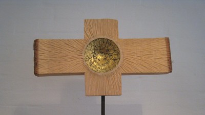 Et kryds af lysebrun træmateriale med en guldfarvet midterdel
