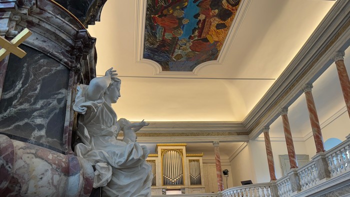 Barok kirkeinteriør med prægtige marmorstatuer, et stort orgel og detaljerede loftsfresker.