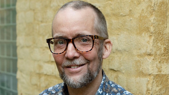 Portrætfoto op ad gul mur: Søren Holst