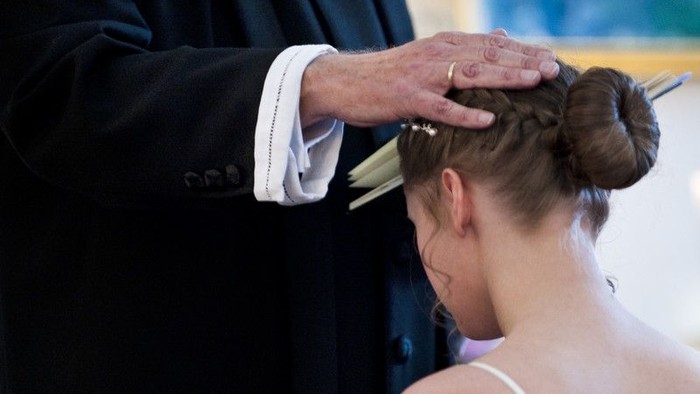 En mand rører en kvindes hoved.