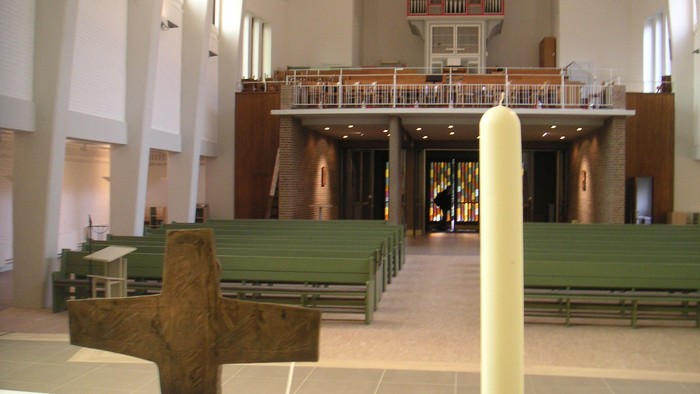 Innenraum einer Kirche mit Kreuz und Kerze
