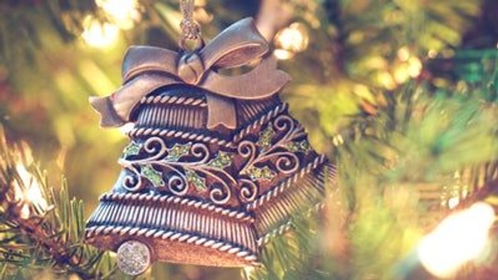 En pyntet julestjerne hænger i et lysende juletree