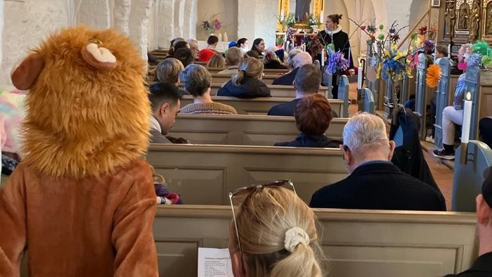 En kirke med folk på bænkene, en person med en bjørnehat.
