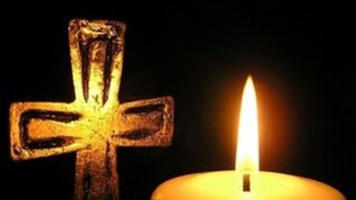 En lysende lyse med en lysende korsformet lysestøbe ved siden