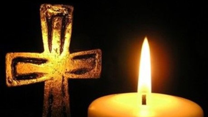 En lysende lyse med en lysende korsformet lysestøbe ved siden