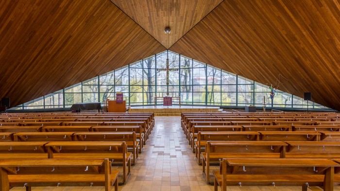 Ein leerer Holzbau mit großen Fenstern und Holzbänken