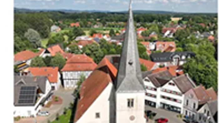 Weiße Kirche mit Dorf im Hintergrund 