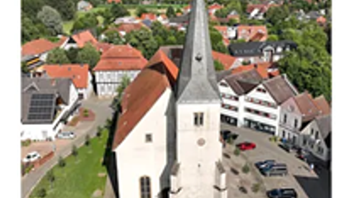 Weiße Kirche mit Dorf im Hintergrund