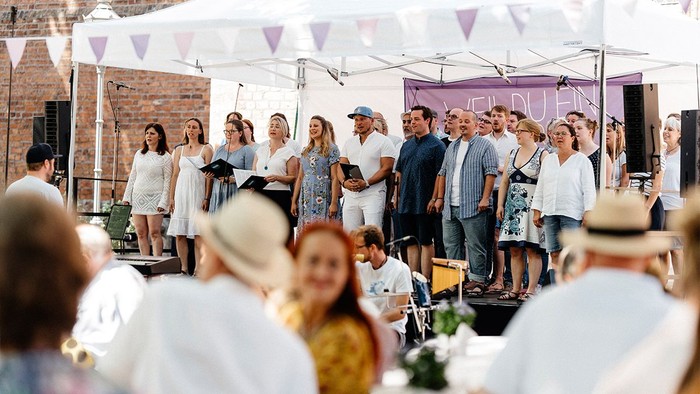 Tauffest: Popchor Spandau singt auf der Bühne, davor sitzen Zuschauer.