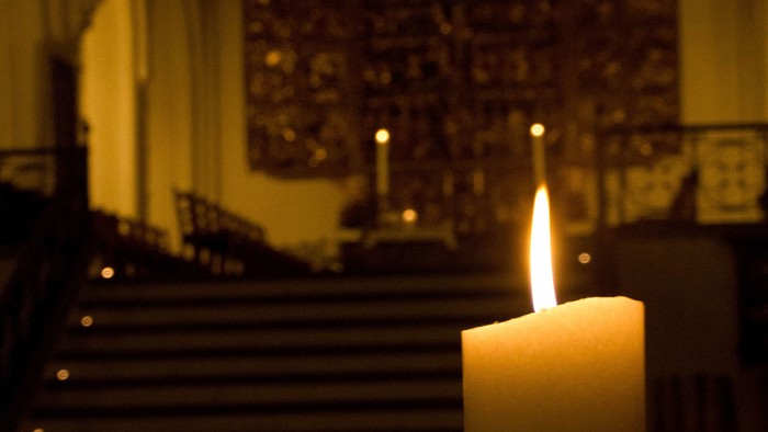 En lysende stearinlys foran alter.
