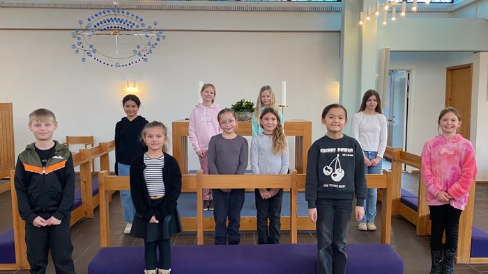 En gruppe børn står sammen i en kirke.