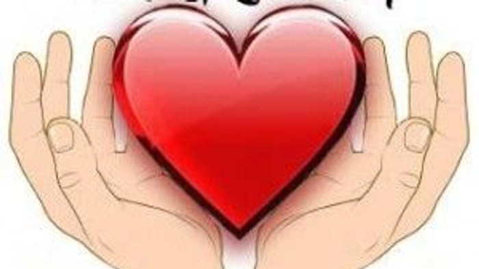 Hands gently holding a red heart, with