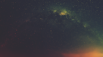 Ein sternenklarer Nachthimmel mit Milchstraße und leuchtenden Farben am Horizont