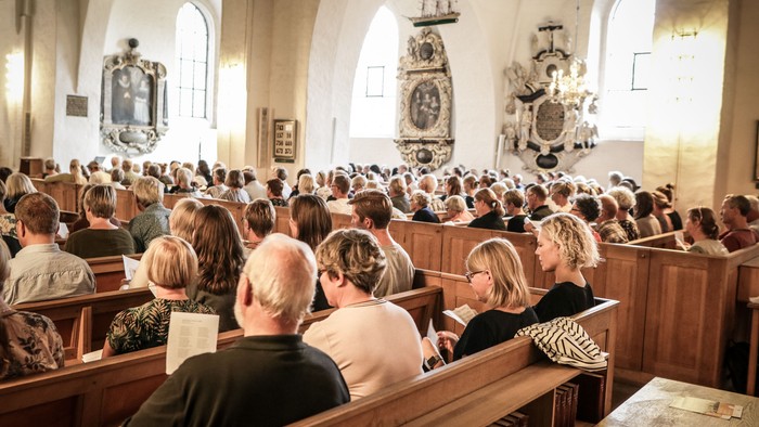 En folkemængde i kirke, der følger en gudstjeneste.