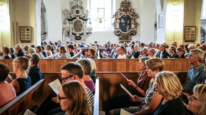En folkemængde i kirke, der deltager i en gudstjeneste.