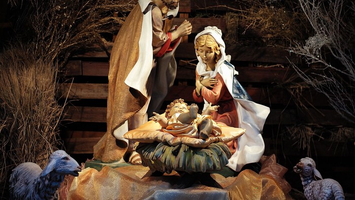 En julekreds med Jesusbarn, Maria og Josef i en hule med dyr.