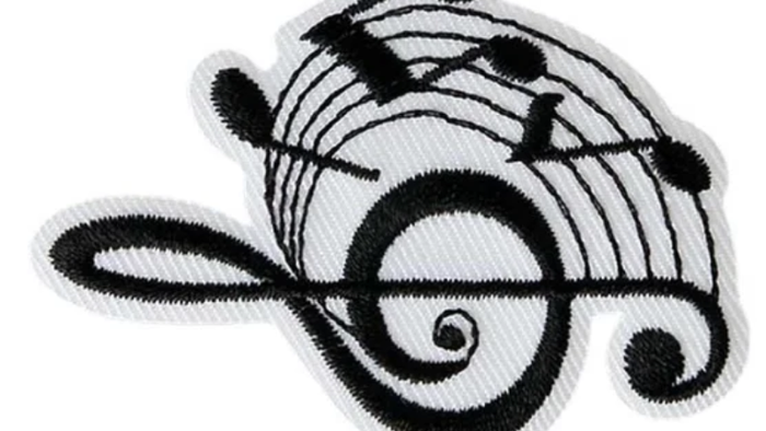 Das Bild zeigt ein Stickerei-Emblem mit Noten und einem Notenkopf.