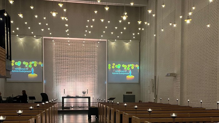 Indre del af kirke med lys og skærme