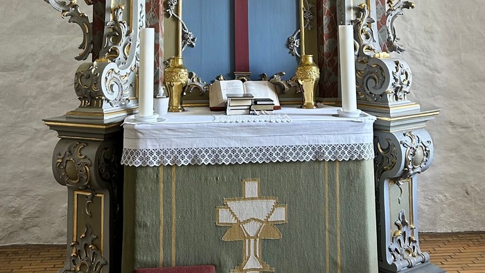 Kirkealter med krucifiks og religiøse dekorationer