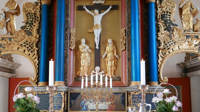 Altertavlen i kirken med dæmpede farver og religiøse symboler