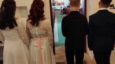 Fire børn står i en kirkegang og ser ind i kirkerummet