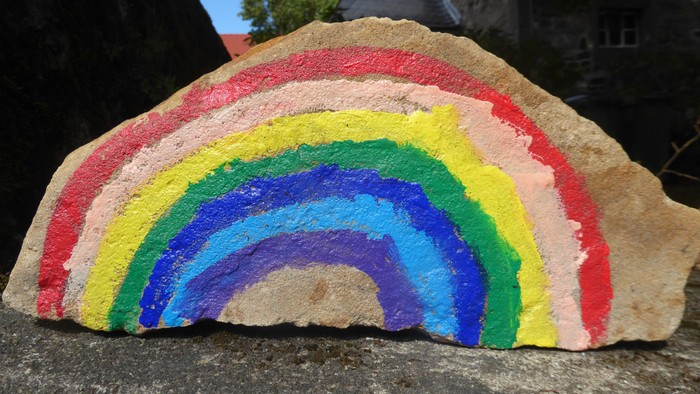 mit einem Regenbogen bemalter Stein an der Ev. Kirche Weickartshain