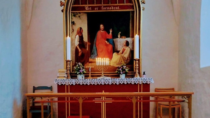 Alter i kirke med lysede lysstaker foran