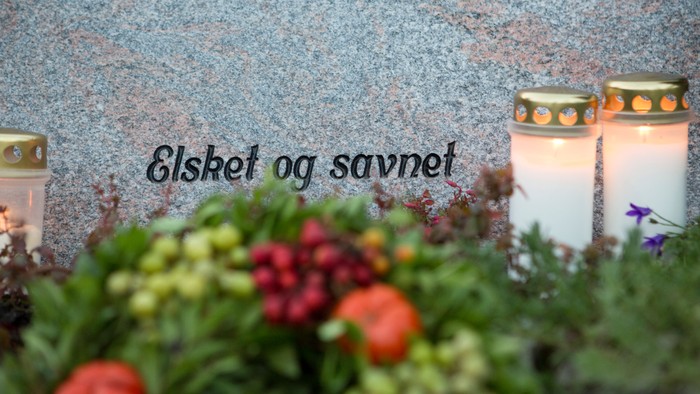 To lys og en blomstentop i forgrunden, 