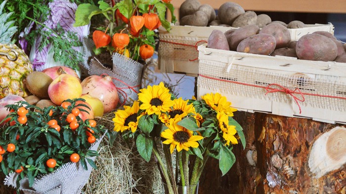 Bunter Obst- und Gemüsestand mit Sonnenblumen