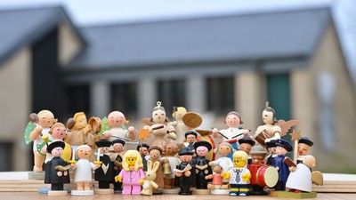 Eine Gruppe von Lego-Minifiguren steht vor einem Haus und spielt Musik