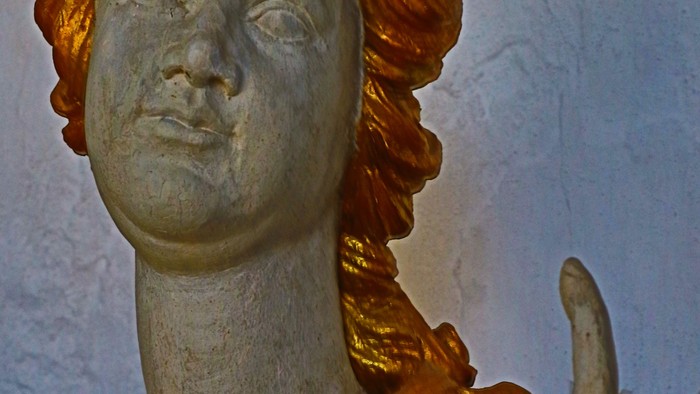 Guld og grøn statue af kvinde med vinges.