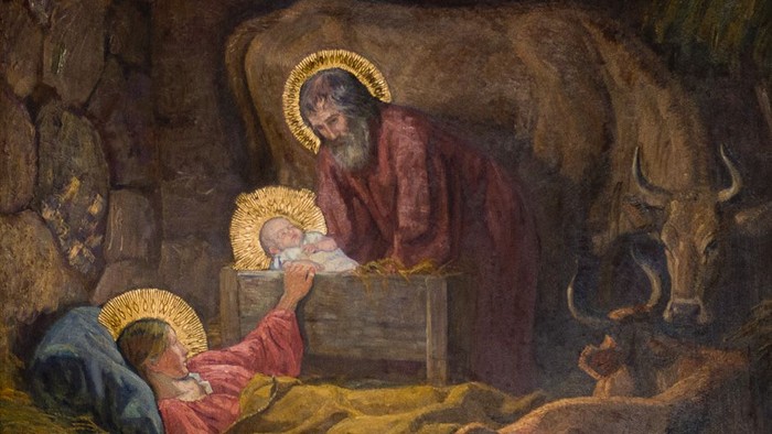 En maleri af Jesusbarnet i en hule med Josef og dyr.