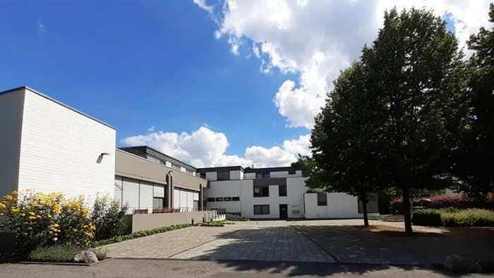 Moderne Wohnanlage mit gepflegtem Garten und klarem Himmel