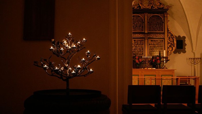En lysetræ og en altertavle i kirke