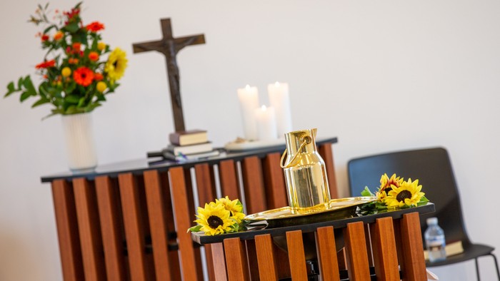 En altertavle med blomster, lysestage og kors