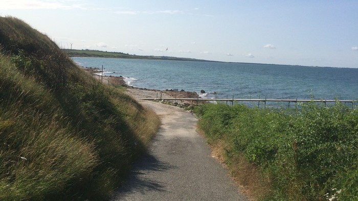 En smal asfaltvej langs kysten med udsigt over havet