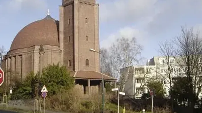 Kirche St. Georg mit rundem Kuppeldach und kegelförmiger Turmspitze.