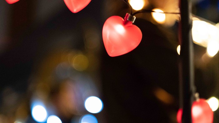 Røde hjerteformede lygter hænger i mørke omgivelser