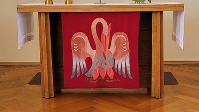 Ein Altar mit Kerzen, Kreuz und farbenfrohem Fenster