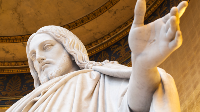 Statue af en mand med udstrakt arm.