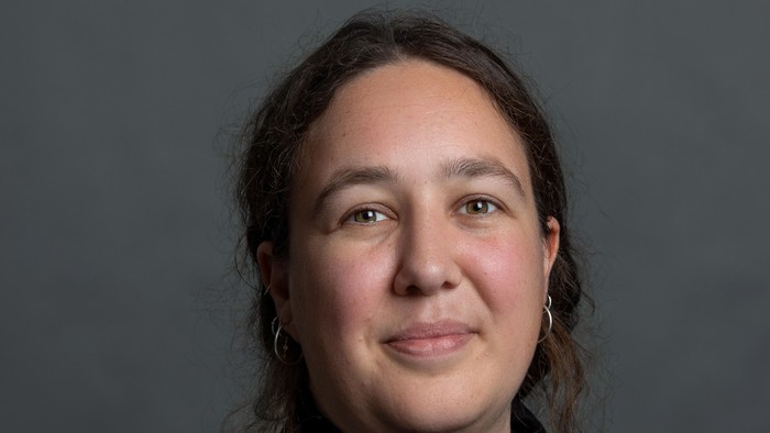 En kvinde med mørke hår og en sort trøje.