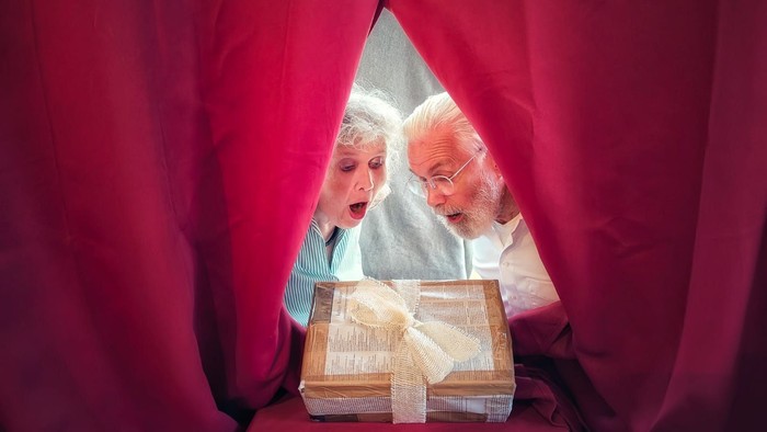 Sabine und Lutz Langner betrachten ein Geschenkpaket