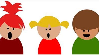 Five børn med forskellige hårfarver og klæder, alle med åbne munder som synes at synge.