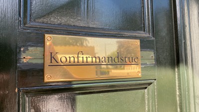 Dør med bronsskilt med indskrivet 'Konfirmandstue'