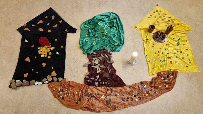 Drei bunte T-Shirts auf einer beigen Oberfläche ausgelegt.