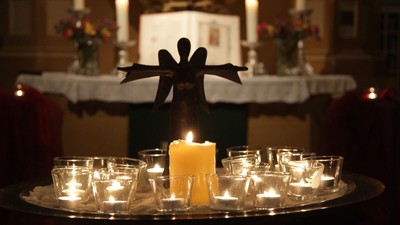 Kirchliche Kerzenarrangement mit Engelstatue