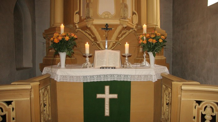 Altar in Kirche mit Kerzen und Blumen