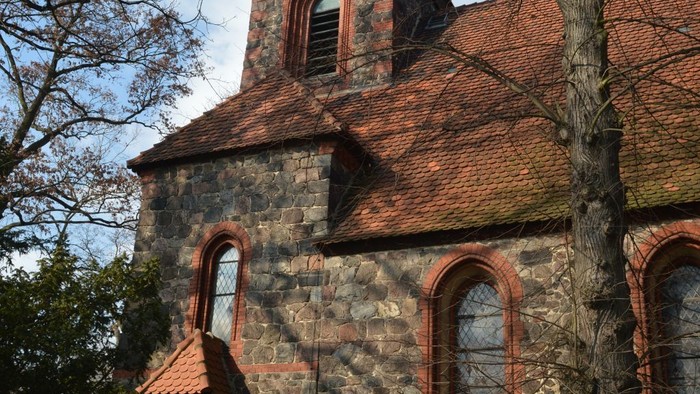 Altes steinernes Gebäude mit rotem Dach und Fensterbögen