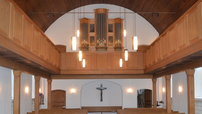 Leere Kirche mit Holzgestühl und roter Teppichbahn